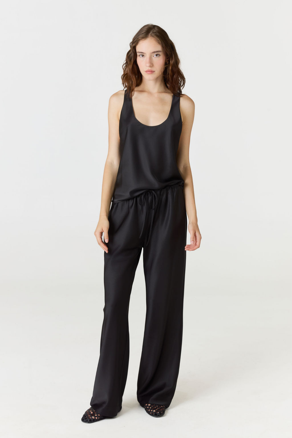 Discover luxury with the Anaiis Silk Tank in black from AOCO. Crafted from premium silk, this chic and versatile camisole offers a flawless drape for any occasion. And Racerback feature.