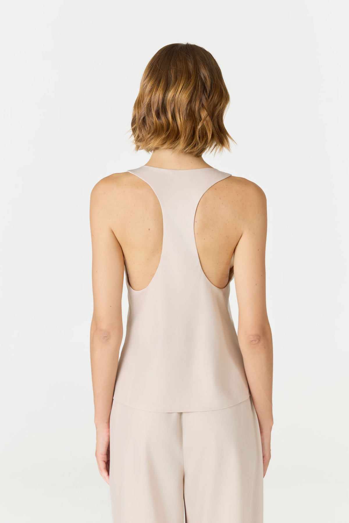 Discover luxury with the Anaiis Silk Tank in champagne cream from AOCO. Crafted from premium silk, this chic and versatile camisole offers a flawless drape for any occasion. And Racerback feature.