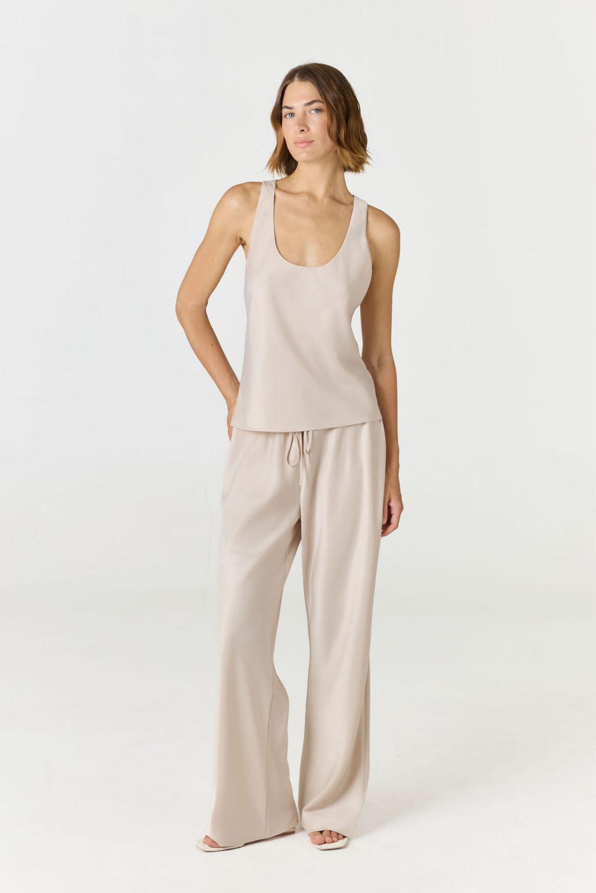 Discover luxury with the Anaiis Silk Tank in champagne cream from AOCO. Crafted from premium silk, this chic and versatile camisole offers a flawless drape for any occasion. And Racerback feature.