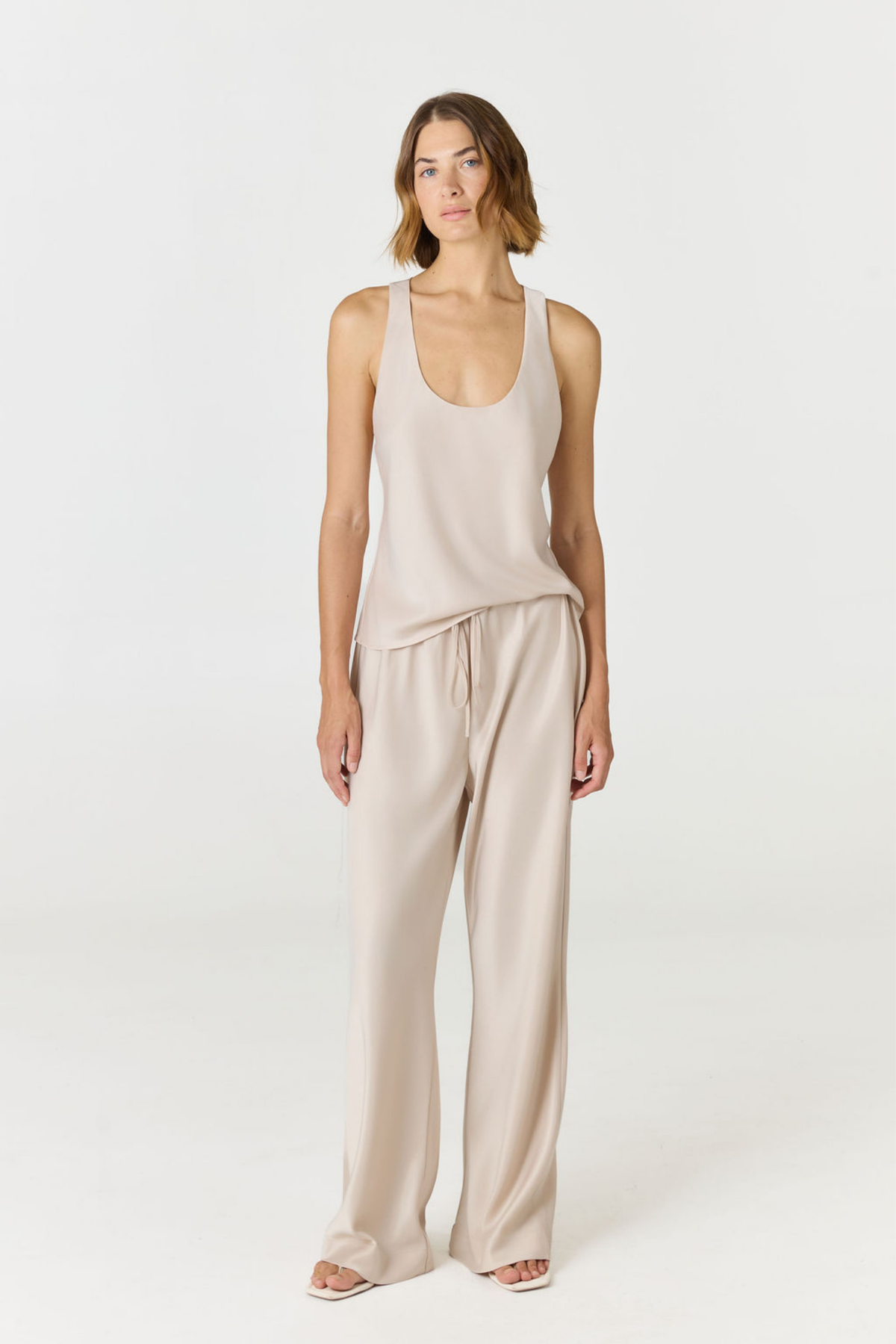 Discover luxury with the Anaiis Silk Tank in champagne cream from AOCO. Crafted from premium silk, this chic and versatile camisole offers a flawless drape for any occasion. And Racerback feature.