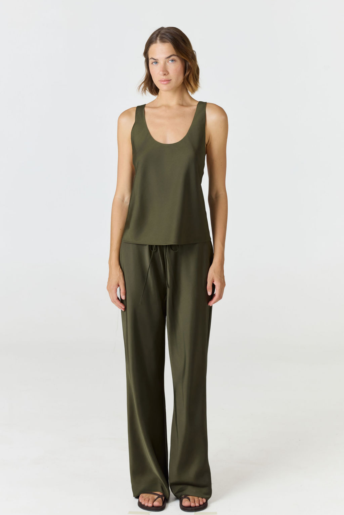 Discover luxury with the Anaiis Silk Tank in olive from AOCO. Crafted from premium silk, this chic and versatile camisole offers a flawless drape for any occasion. And Racerback feature.