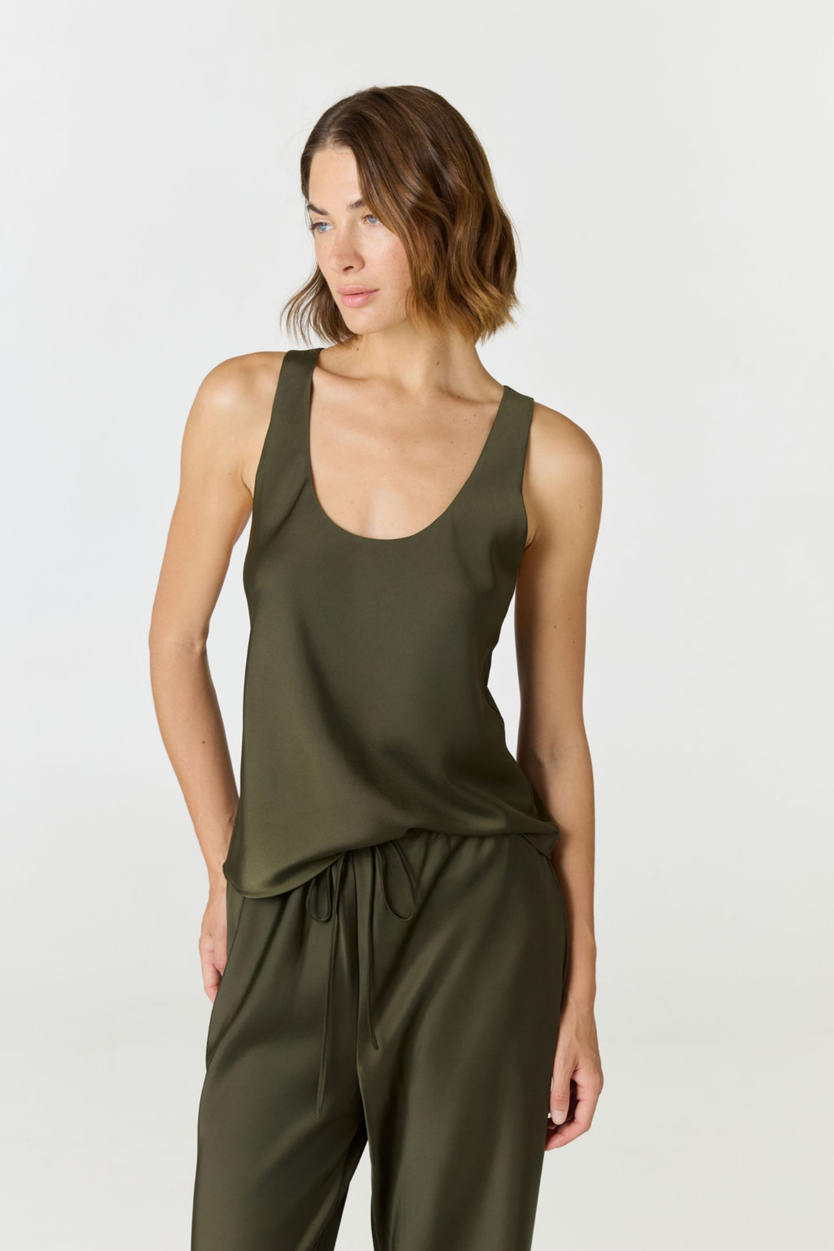 Discover luxury with the Anaiis Silk Tank in olive from AOCO. Crafted from premium silk, this chic and versatile camisole offers a flawless drape for any occasion. And Racerback feature.