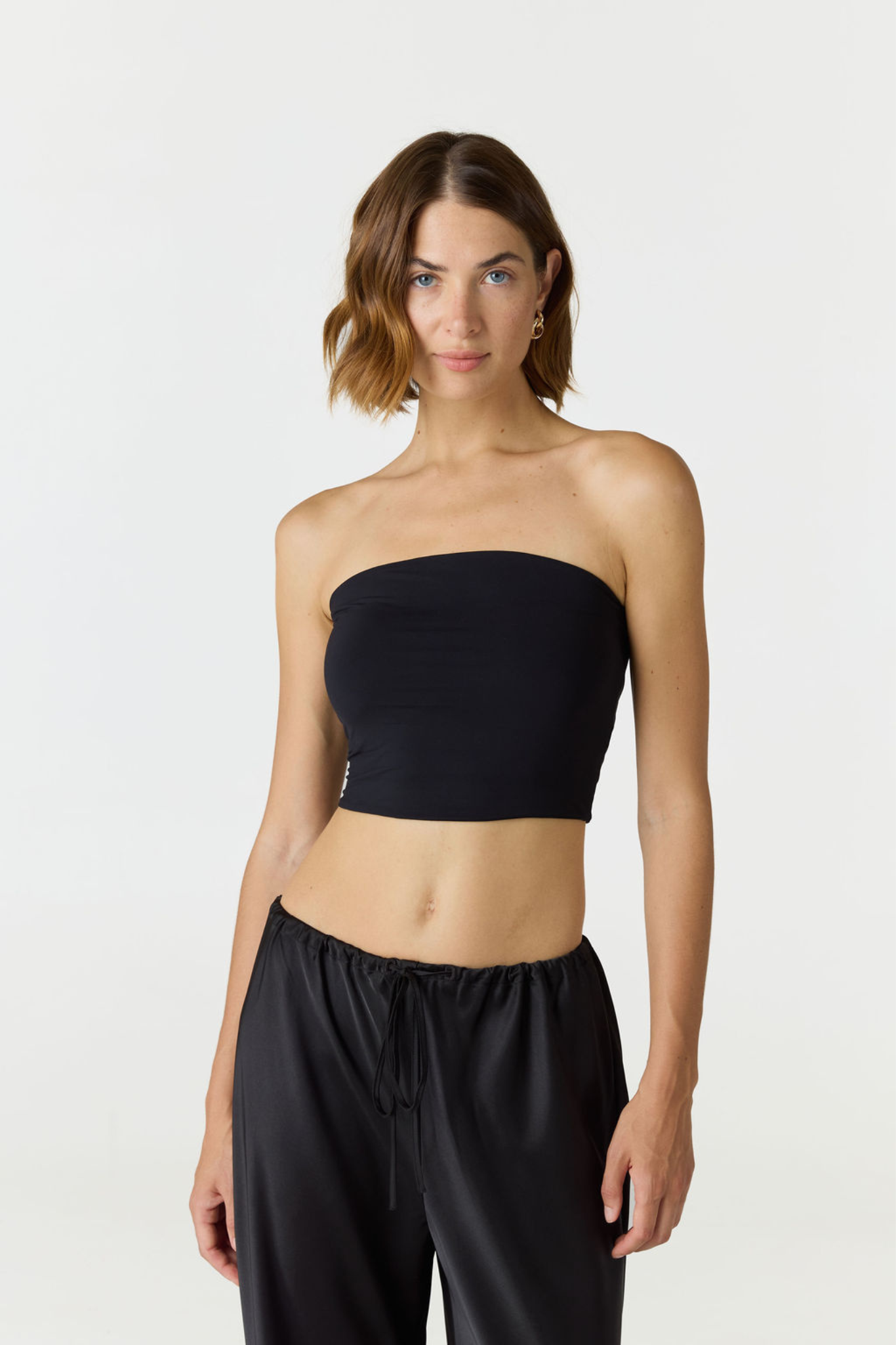 Elevate your warm-weather wardrobe with the Edie Bandeau Top in Black from AOCO. This chic strapless design offers a flattering fit and endless style possibilities.