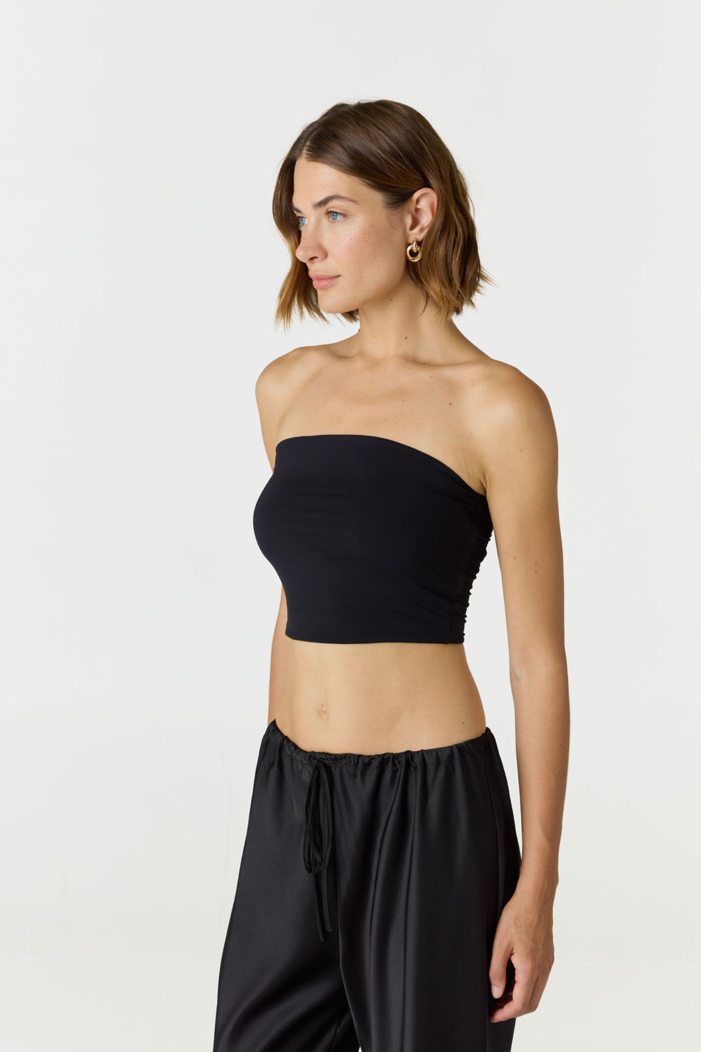 Elevate your warm-weather wardrobe with the Edie Bandeau Top in Black from AOCO. This chic strapless design offers a flattering fit and endless style possibilities.