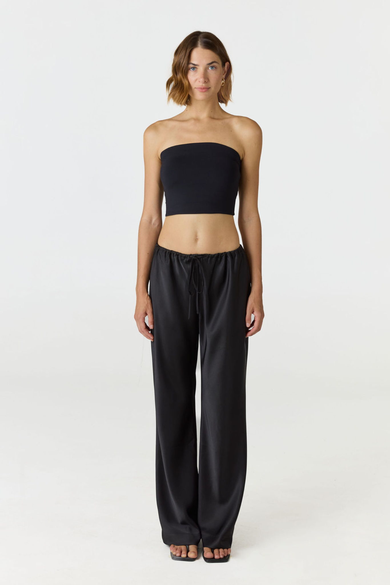 Elevate your warm-weather wardrobe with the Edie Bandeau Top in Black from AOCO. This chic strapless design offers a flattering fit and endless style possibilities.