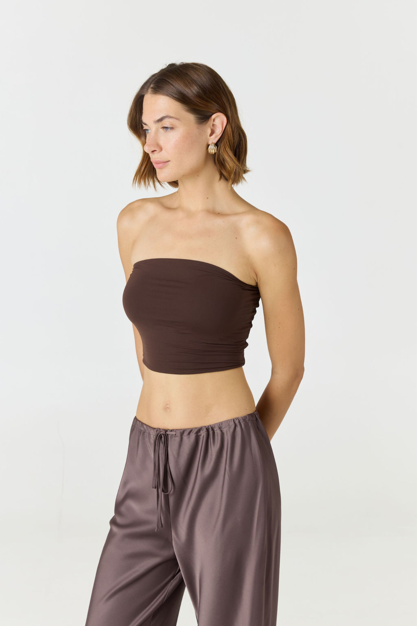 Elevate your warm-weather wardrobe with the Edie Bandeau Top in Espresso from AOCO. This chic strapless design offers a flattering fit and endless style possibilities.