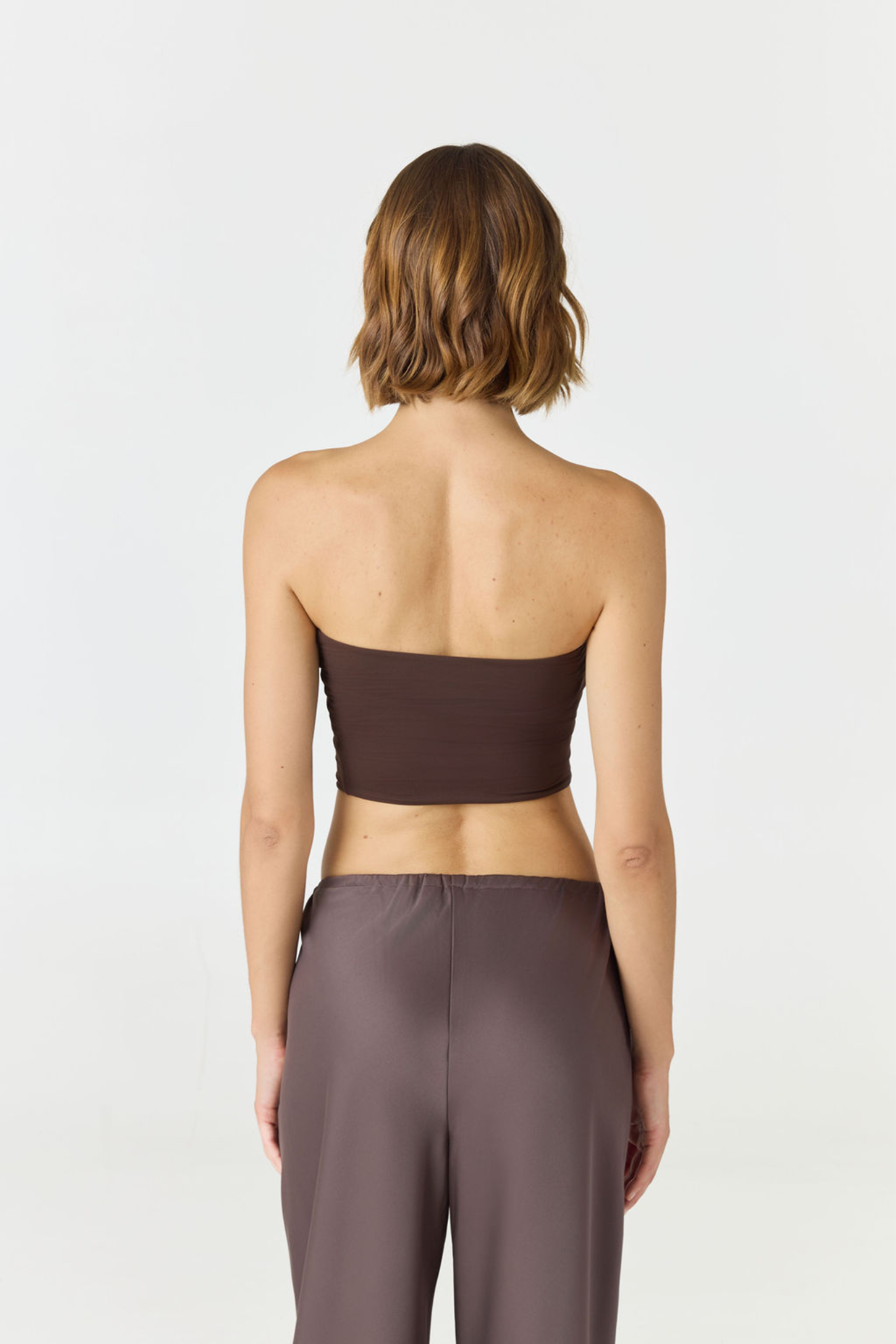 Elevate your warm-weather wardrobe with the Edie Bandeau Top in Espresso from AOCO. This chic strapless design offers a flattering fit and endless style possibilities.