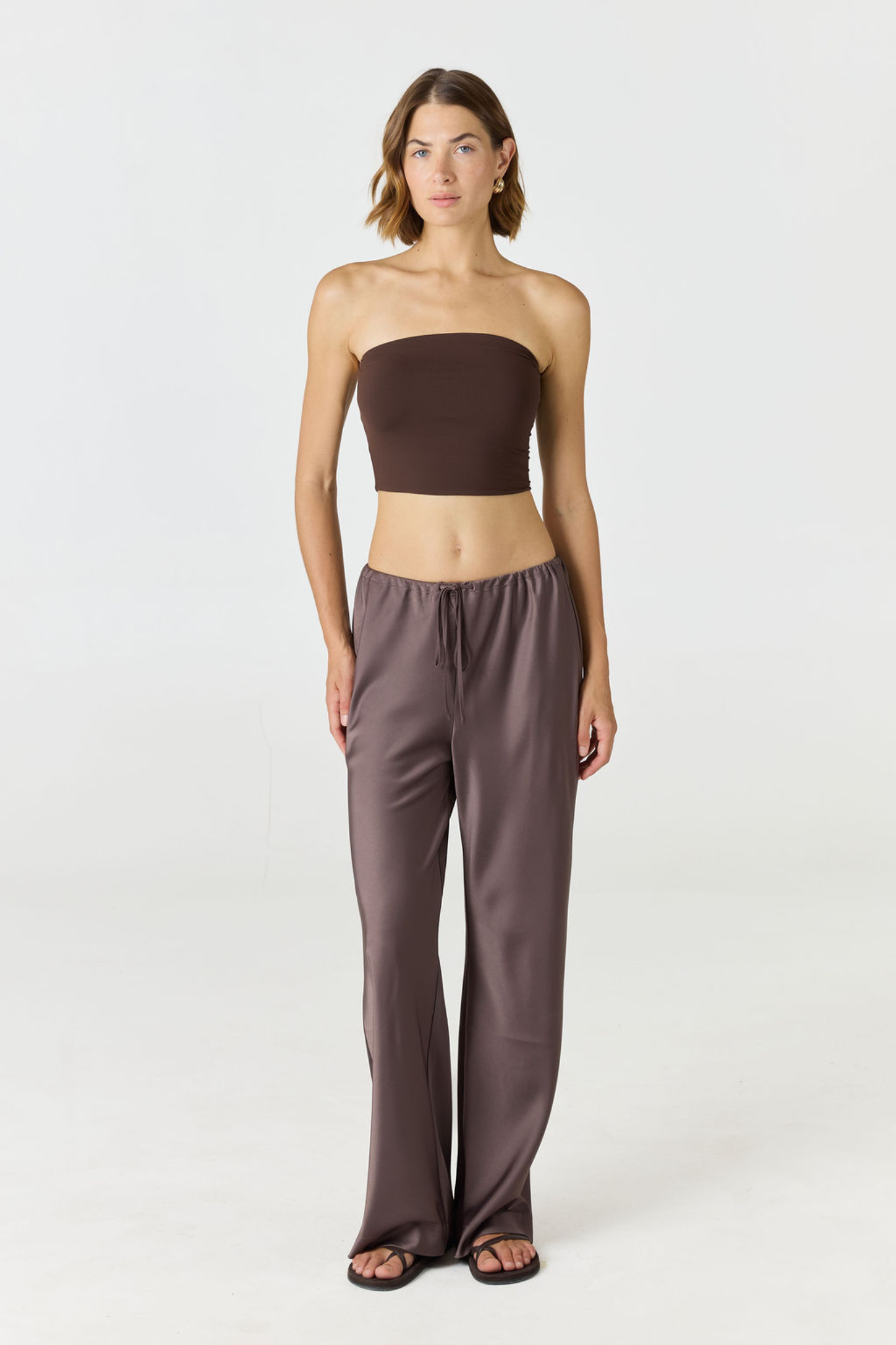 Elevate your warm-weather wardrobe with the Edie Bandeau Top in Espresso from AOCO. This chic strapless design offers a flattering fit and endless style possibilities.