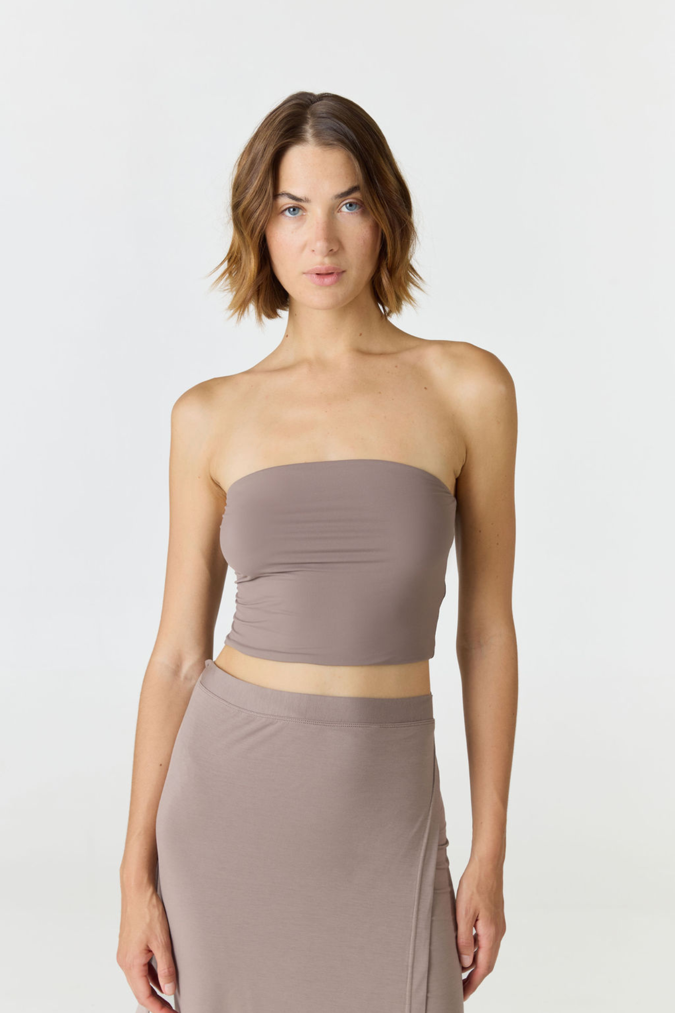 Elevate your warm-weather wardrobe with the Edie Bandeau Top in Taupe from AOCO. This chic strapless design offers a flattering fit and endless style possibilities.