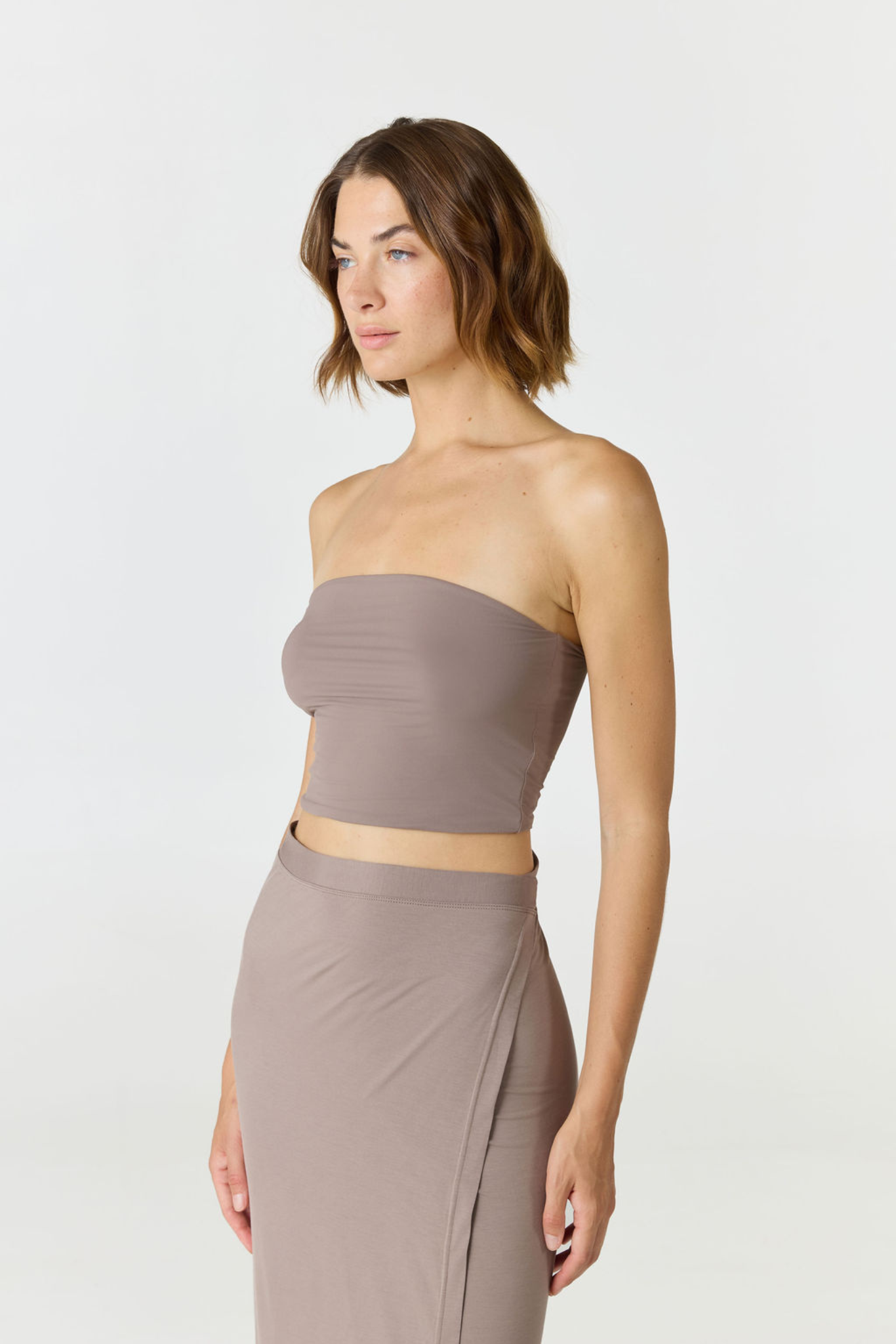 Elevate your warm-weather wardrobe with the Edie Bandeau Top in Taupe from AOCO. This chic strapless design offers a flattering fit and endless style possibilities.