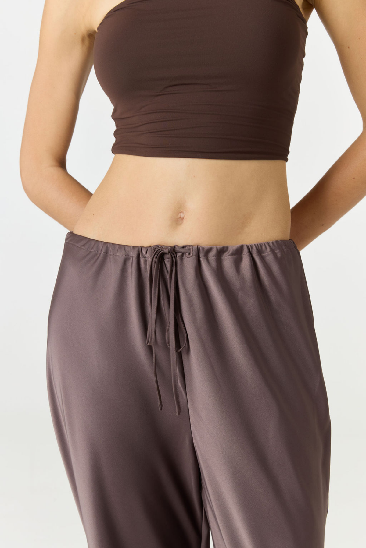 Experience ultimate comfort and sophistication with the Gia Silk Pants in brown by AOCO. These luxury trousers offer a flattering fit and an elegant, flawless drape.