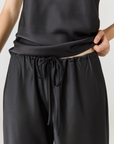 Experience ultimate comfort and sophistication with the Gia Silk Pants in black by AOCO. These luxury trousers offer a flattering fit and an elegant, flawless drape.